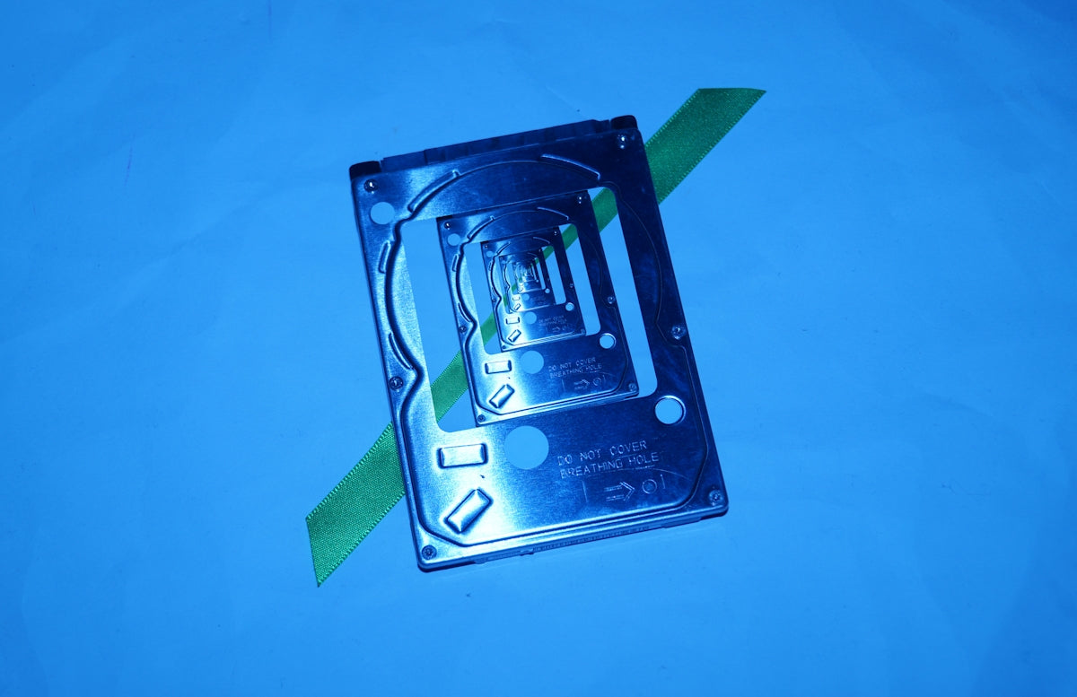 A computer hard drive with a green arrow on it